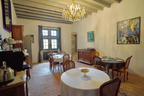 a living room with tables and chairs and a chandelier at Château de Rancé in Genay