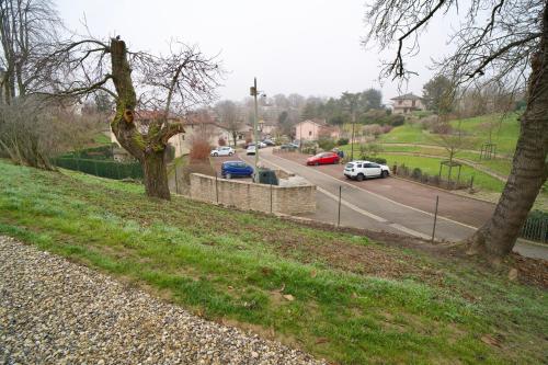 a road with cars parked on the side of the road at Château de Rancé in Genay