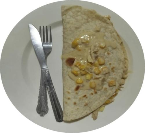 a white plate with a piece of food with a fork and knife at Hostal Finca San Martín De Loba in Los Naranjos