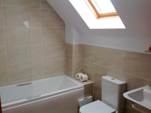 a bathroom with a tub and a toilet and a skylight at 244 Seatown Cullen Moray Scotland in Cullen