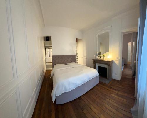 une chambre blanche avec un lit et un bureau dans l'établissement Prestige à Paris Luxe, Calme et Proche Tour Eiffel et Champs-Élysées, à Paris
