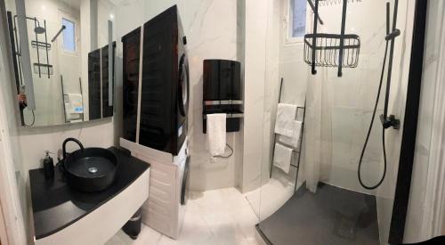 La salle de bains est pourvue d'une télévision, d'un lavabo et d'une douche. dans l'établissement Prestige à Paris Luxe, Calme et Proche Tour Eiffel et Champs-Élysées, à Paris