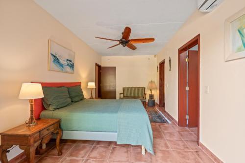 a bedroom with a bed and a ceiling fan at Villa Casablanca in Willemstad
