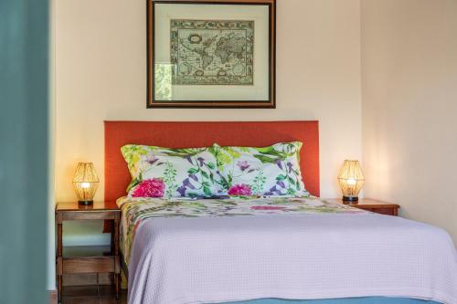 a bed with an orange headboard and two tables with lamps at Villa Casablanca in Willemstad