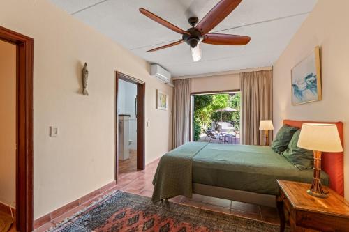 a bedroom with a bed and a ceiling fan at Villa Casablanca in Willemstad