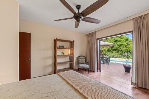 a bedroom with a bed and a ceiling fan at Villa Casablanca in Willemstad