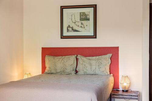 a bedroom with a bed with a red headboard at Villa Casablanca in Willemstad