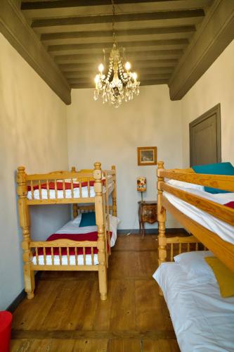 a bedroom with two bunk beds and a chandelier at Château de Rancé in Genay
