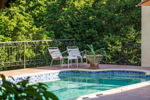 two chairs and a table next to a swimming pool at Villa Casablanca in Willemstad