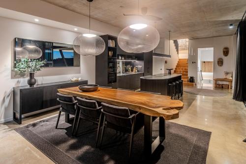 a dining room with a wooden table and chairs at Haven House at Hamilton Island in Hamilton Island