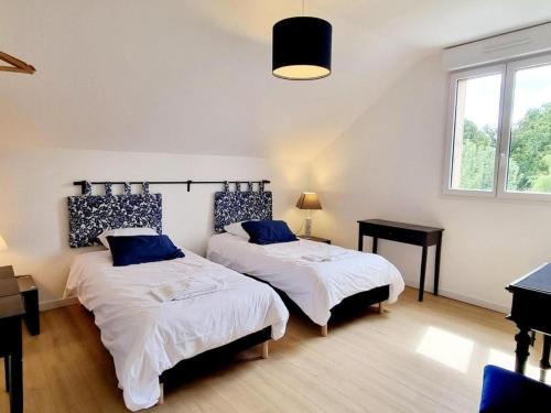 Un dormitorio con dos camas con almohadas azules. en Gîte de charme avec piscine privée, en Paray-Douaville