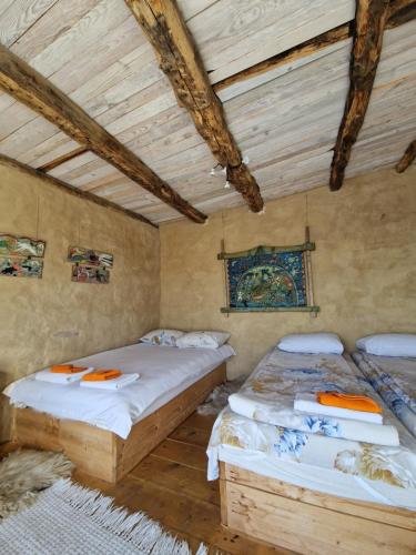 two beds in a room with wooden ceilings at Вила 'Гнездото', Villa 'The nest', Rhodope mountains, Banite in Vishnevo