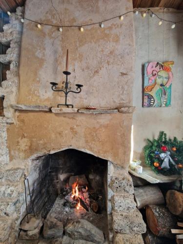 a stone fireplace with a fire in it at Вила 'Гнездото', Villa 'The nest', Rhodope mountains, Banite in Vishnevo