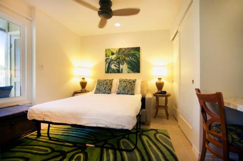 a bedroom with a bed with two lamps and a window at Castle Kauai Kailani in Kapaa
