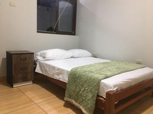 ein Schlafzimmer mit einem Bett, einer Kommode und einem Spiegel in der Unterkunft Depa en 1er piso,cochera, close to the plaza and UNSCH in Ayacucho