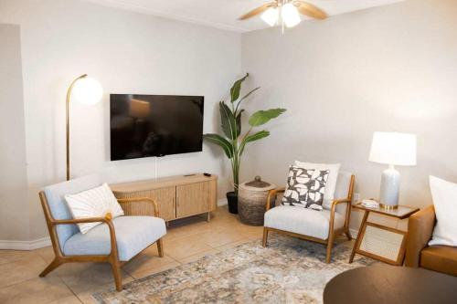 a living room with two chairs and a tv at 2 Bed 2 Bath 1st Floor Condo w Pool By Beach in South Padre Island