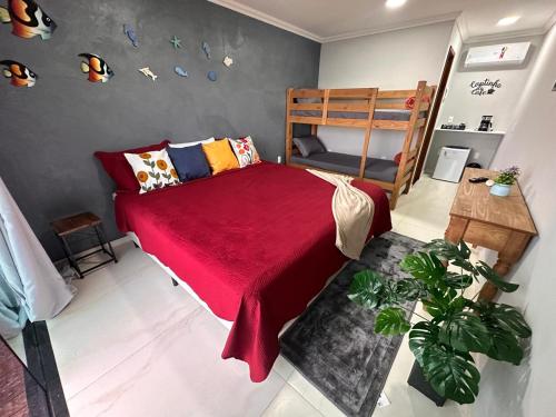 a bedroom with a bed with a red blanket at Recanto do Leste in Angra dos Reis