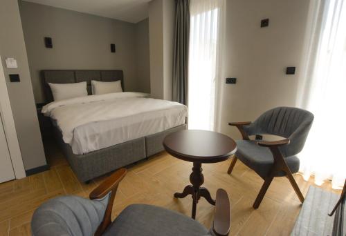 a bedroom with a bed and a table and chairs at Ağva Casa Rosa Bungalov Otel in Sile
