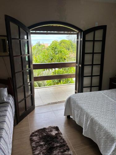 a bedroom with a bed and an open door at Casa Barra Mar in Saquarema