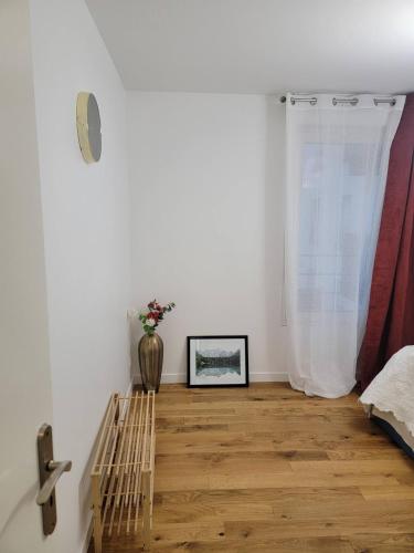 サン・トゥアンにあるChambre cosy près de Paris dans un appartement partagéの花瓶が並ぶウッドフロアの客室です。