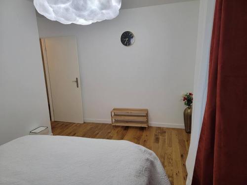 サン・トゥアンにあるChambre cosy près de Paris dans un appartement partagéの白い天井のベッドルーム1室(白いベッド1台付)