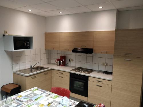 una piccola cucina con mobili in legno e tavolo di Maisonjoske a Beaulieu