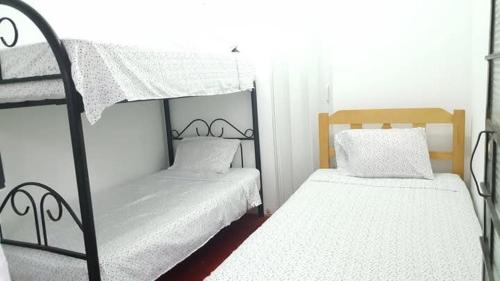 a bedroom with two bunk beds with white sheets at Hospedaje snack bar titanic in Ica