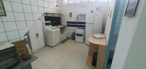 a small kitchen with white appliances in a room at Quarto com cozinha funcional in Guarapari