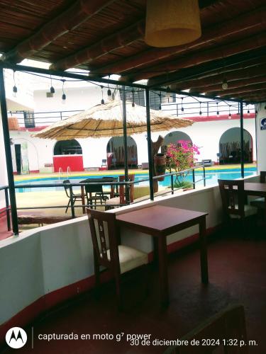 an outdoor patio with tables and chairs and a pool at Hospedaje snack bar titanic in Ica