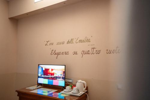 a room with a desk with a computer on a wall at Hotel Terme Salvarola in Sassuolo