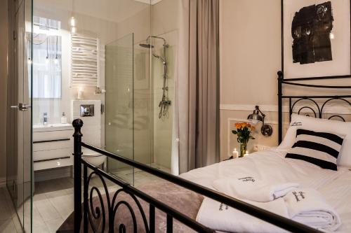 um quarto com uma cabina de duche em vidro e uma cama em Imagine Apartments na Cracóvia