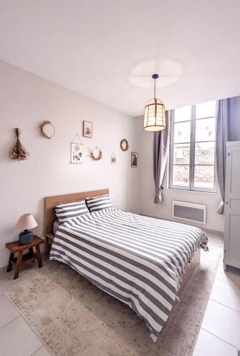 - une chambre avec un lit et une couette en noir et blanc rayée dans l'établissement Le Nayrac l Hypercentre l Parking privé, à Castres