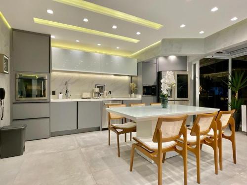 een keuken met een grote witte tafel en stoelen bij Top of the Alpha Duplex in Barueri