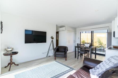 a living room with a couch and a table at Nautilus self-catering cottage in Maraetai