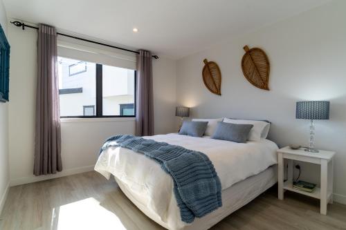 une chambre avec un grand lit et une fenêtre dans l'établissement Nautilus self-catering cottage, à Maraetai