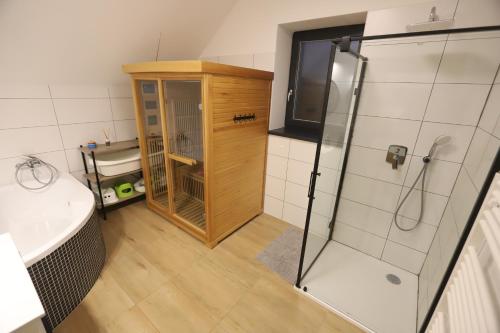 Un baño con ducha, lavabo y bañera. en Chata u Potůčku, en Trojanovice