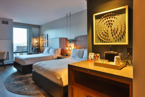 a hotel room with two beds and a desk at Hotel Indigo - Silverthorne by IHG in Silverthorne