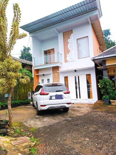 a white car parked in front of a house at Villa Kanaya in Sukapura