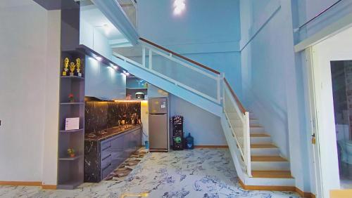 a staircase in a room with a blue wall at Villa Kanaya in Sukapura