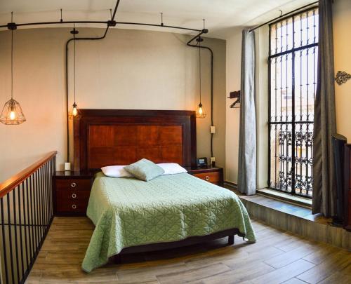 ein Schlafzimmer mit einem Bett und einem großen Fenster in der Unterkunft Studio Loft Corina in Morelia