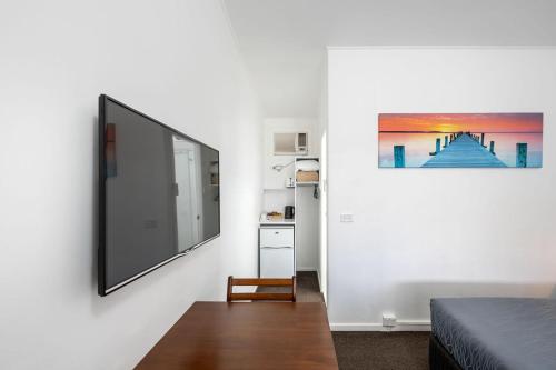 a bedroom with a flat screen tv on a wall at Royal Motel Tenterfield in Tenterfield