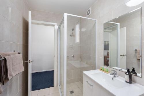 a bathroom with a shower and a sink and a mirror at Royal Motel Tenterfield in Tenterfield