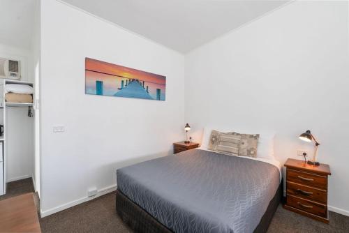 a bedroom with a bed and a painting on the wall at Royal Motel Tenterfield in Tenterfield