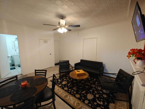a living room with a table and chairs and a ceiling fan at JSQ Apartment, 5 Mins from PATH Station in Jersey City