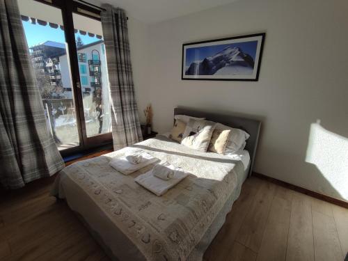 une chambre avec un lit avec des serviettes dessus dans l'établissement Cozy Alpine Studio, à Chamonix-Mont-Blanc