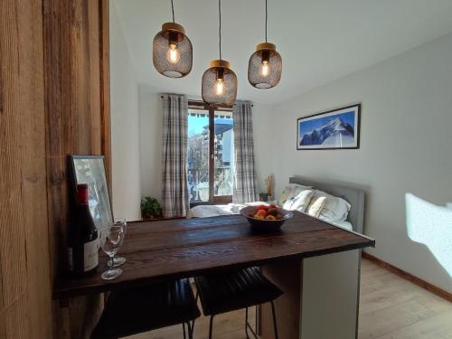 une cuisine avec une table avec un bol de fruits dessus dans l'établissement Cozy Alpine Studio, à Chamonix-Mont-Blanc