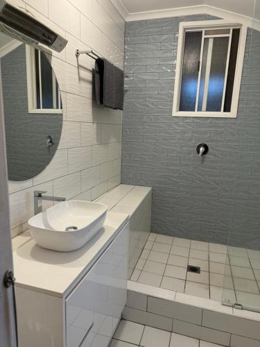 a white bathroom with a sink and a mirror at Hotel Koorawatha in Koorawatha