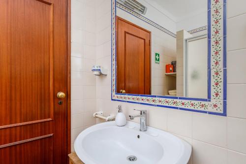 a bathroom with a sink and a mirror at Casa de Colares - Sintra Beach Pool Surf Getaway Work and Play in Colares