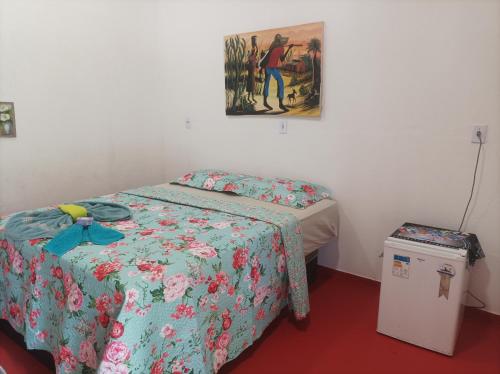 a room with two beds and a painting on the wall at Siete aconchego in Porto Seguro