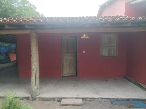 a red house with two doors and a porch at Siete aconchego in Porto Seguro